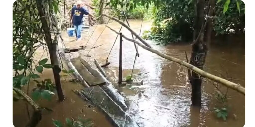 Moradores esperam reconstrução de ponte há quatro anos e se arriscam em travessia: ‘Pinguela com a água na cintura’